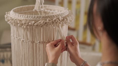 home hobby, knitting macrame. women's hands knit an ornament with thick threads.