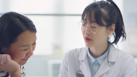 Asian Woman and Female Doctor Using Tablet on Consultation