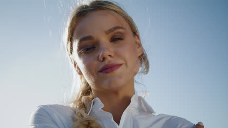 portrait blonde woman posing sky background. smiling girl face looking camera