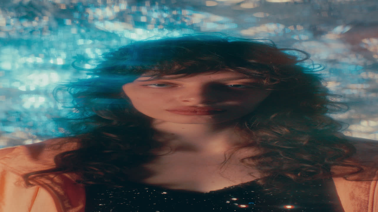 Portrait of Beautiful Girl among Blurred Lights in front of Sparkling Backdrop