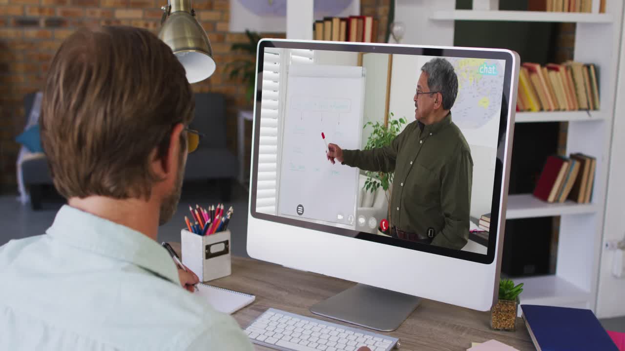 estudiante masculino caucásico usando la computadora en videollamada con el profesor masculino