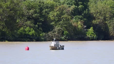 small boat moving near red buoy