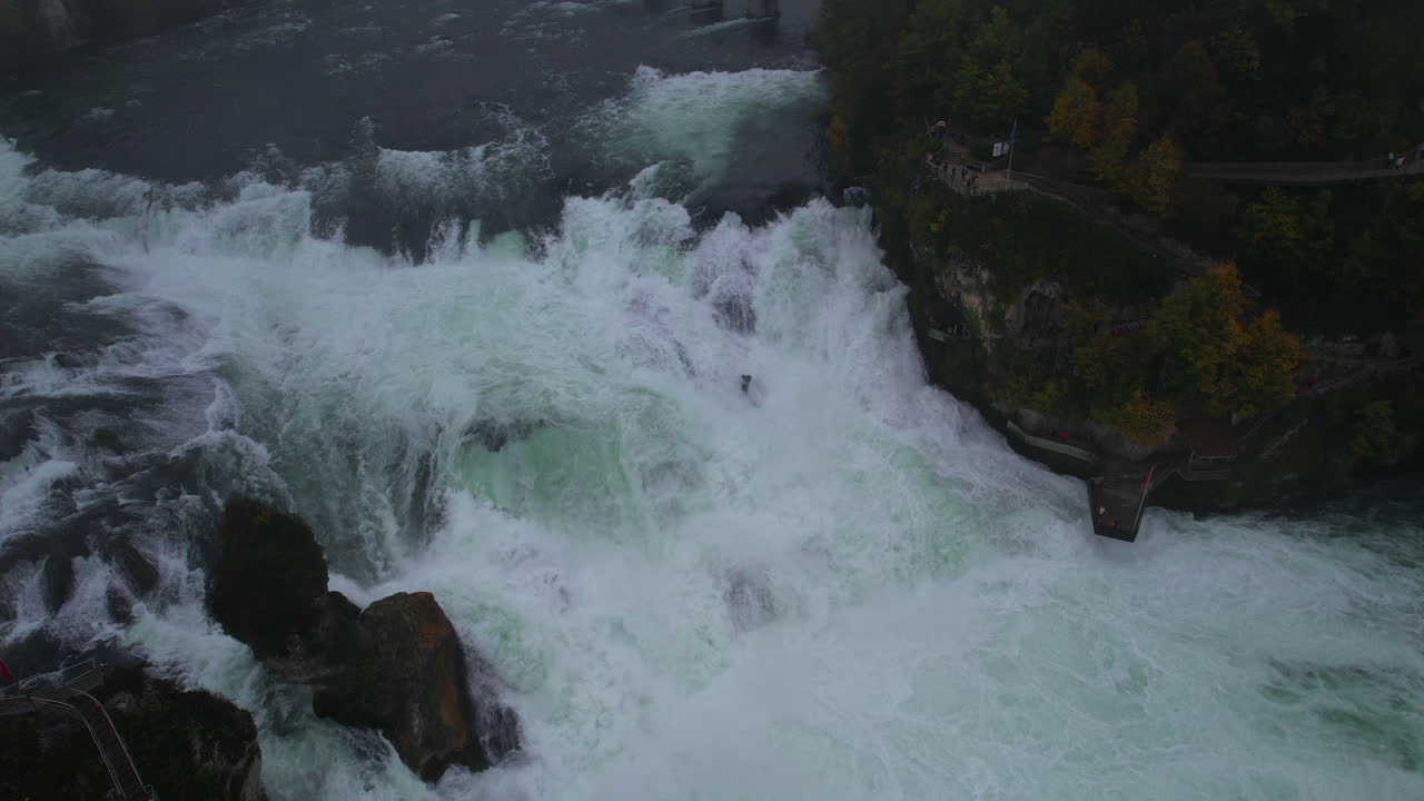 Aerial view of Rhine Falls powerful cascading water, Laufen Castle, and foggy landscape in Switzerland