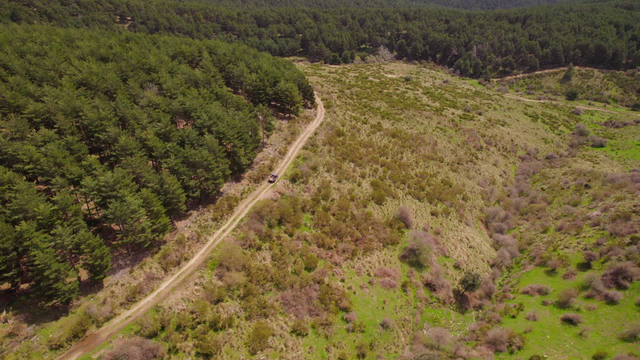vista aérea que muestra la conducción de vehículos con errores en caminos rurales al atardecer rodeados de campos verdes y plantas - el espinar, españa
