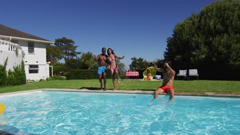 diverse group of friends having jumping into a swimming pool