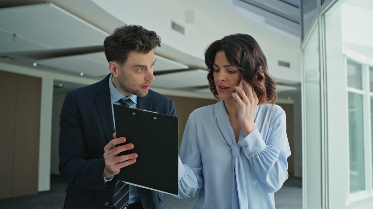 Woman ceo talking mobile phone walking office hallway with man secretary closeup