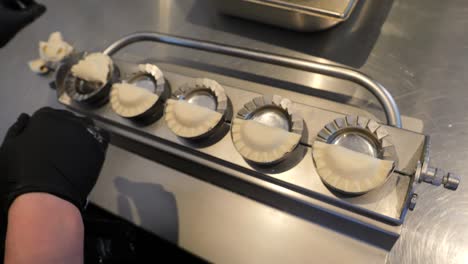 the chef removes stuffed dumplings from the mold