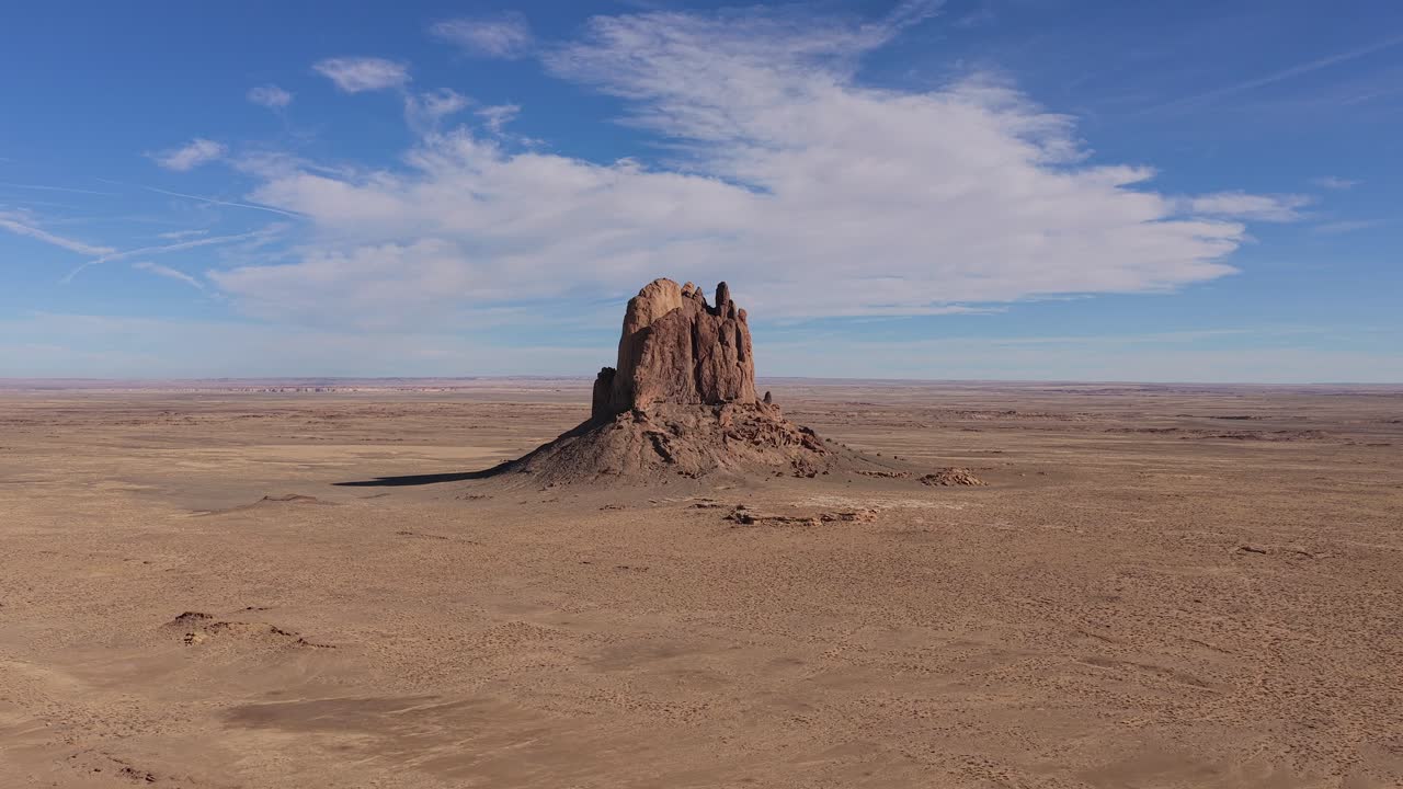 Dronebeeld toont een afgelegen sciencefiction-buitenpostmonoliet op een onvruchtbare woestijnplaneet, waarbij de geïsoleerde rotsformatie binnen een desolaat en uitgestrekt futuristisch wildernislandschap wordt benadrukt.