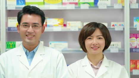 young pharmacist packing chronic medicine and prescription medication on pharmacy shelves, happy chemist smiling laughing ready for customer orders