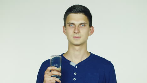 a man drinks water from a glass on a white background hd video