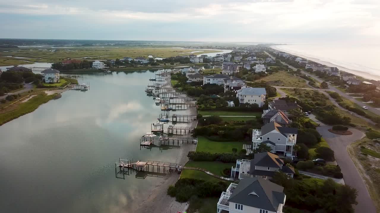 Sorvolo all'alba con drone e panoramica a sinistra del porto interno di Figure Eight Island dalla spiaggia di Wilmington, Carolina del Nord