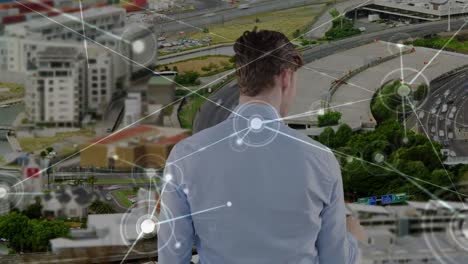 Animation-of-caucasian-businessman-touching-virtual-screen-and-network-of-connections-over-cityscape
