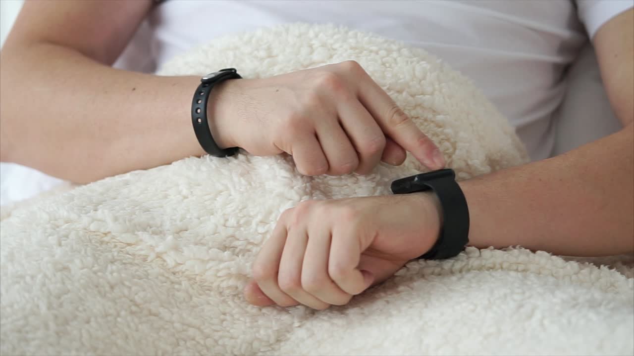 Person wearing a smartwatch in bed