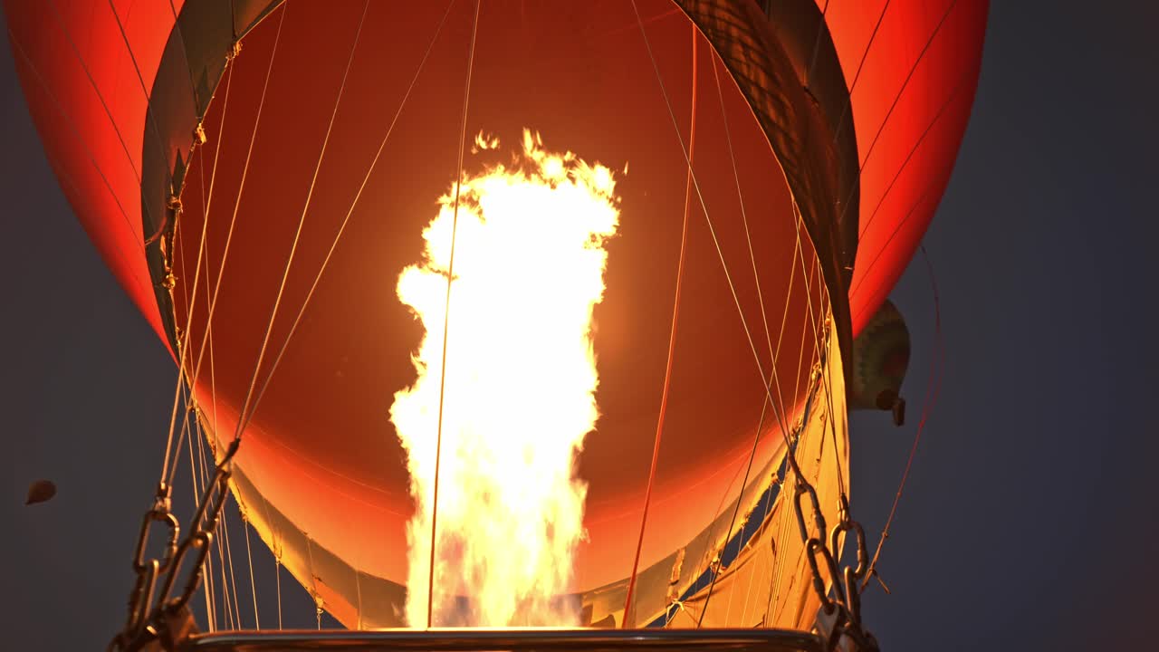 Un primo piano drammatico che cattura il momento intenso del gonfiaggio prima di un volo all'alba sulla sponda occidentale di Luxor, Egitto.
