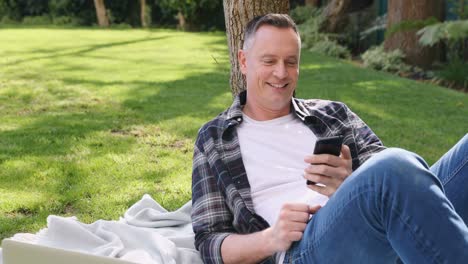 hombre usando teléfono móvil en el jardín 4k