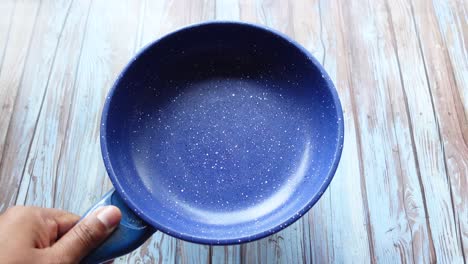 blue frying pan on wooden table