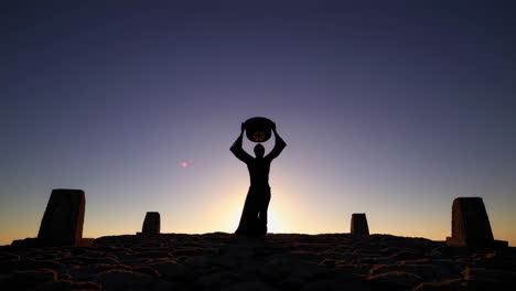 Silhouette of a Person on a Hilltop at Sunrise/Sunset