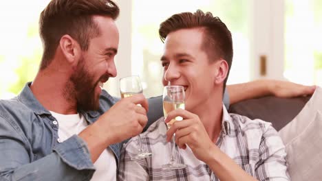una pareja homosexual bebiendo champán.