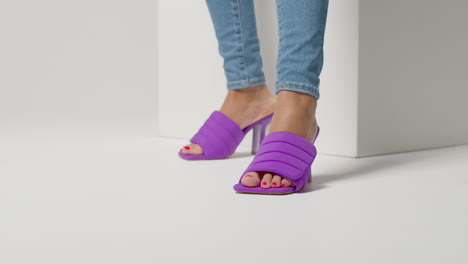 close up of female social media influencer producing user generated content wearing beautiful pair of purple shoes