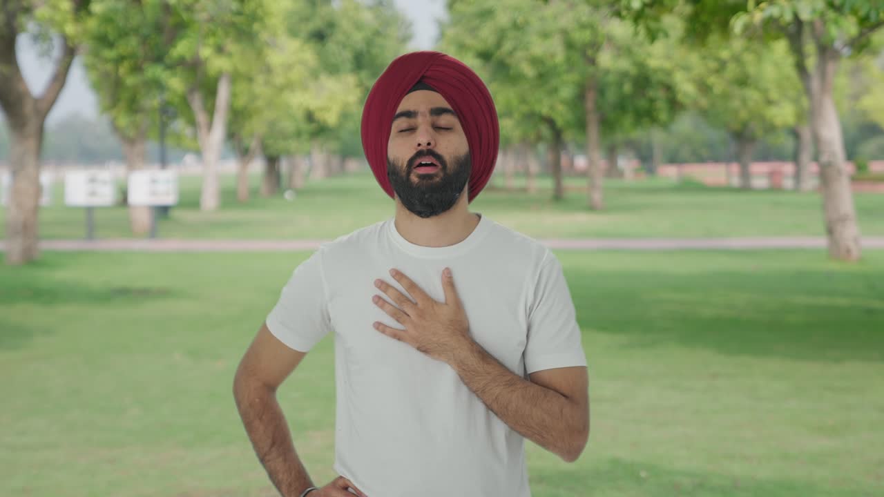 Pria India Sikh yang sakit menderita flu dan batuk di taman