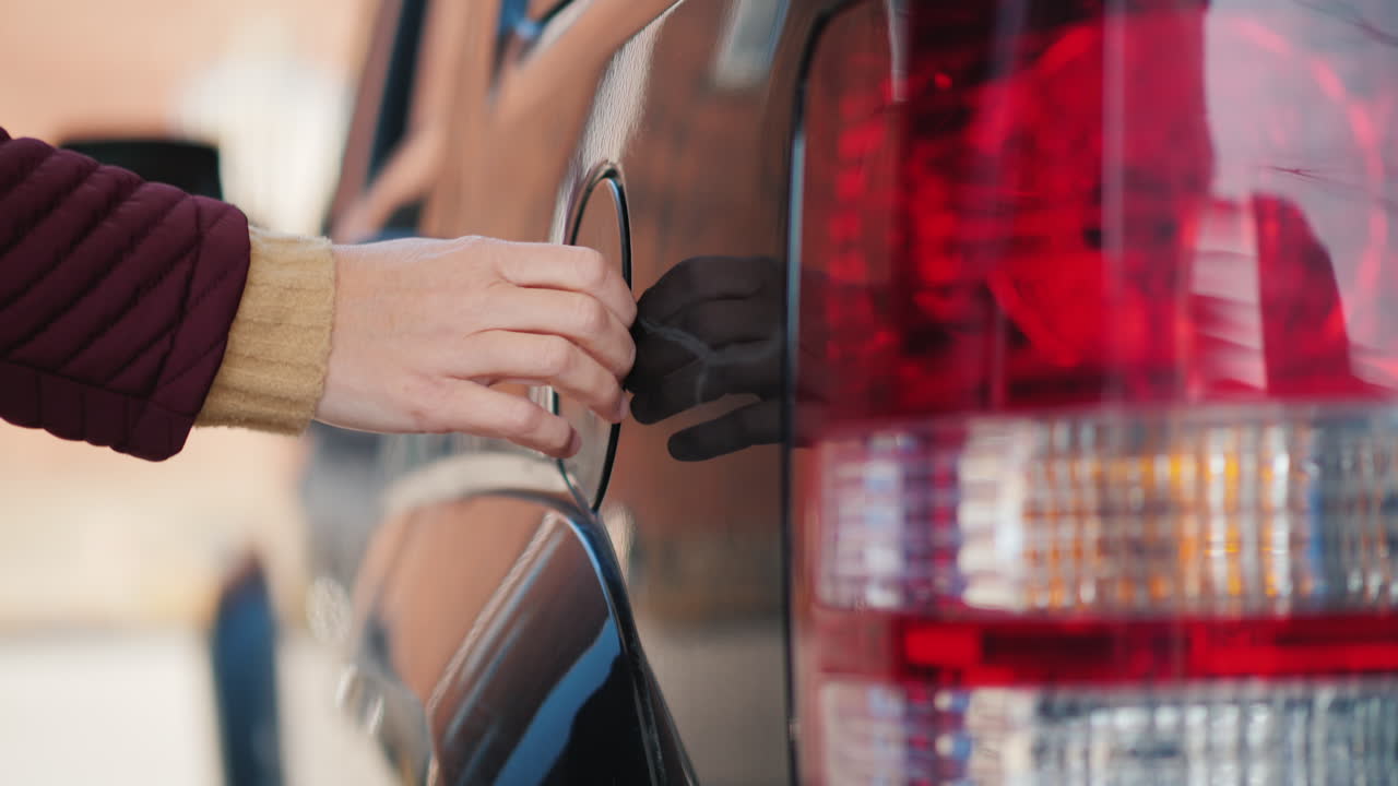 mujer repostando coche negro
