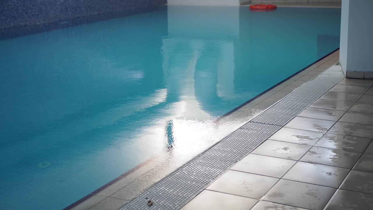 An indoor swimming pool with clear blue water and white tiles