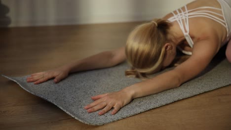 closeup of a woman doing yoga on a gymnastic mat stretching exercises closeup of a woman doing yoga on a gymnastic mat stretching exercises indoor yoga healthy lifestyle concept