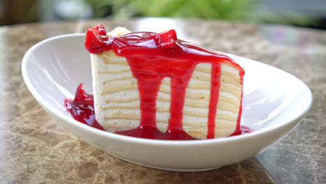 pastel de crepe de vainilla con salsa de frambuesa y fresa