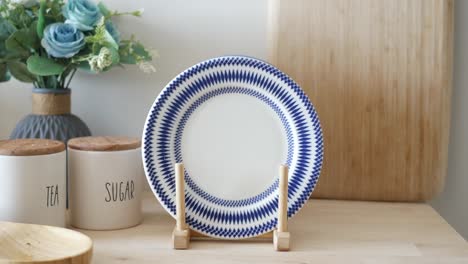 blue and white decorated plate on wooden stand