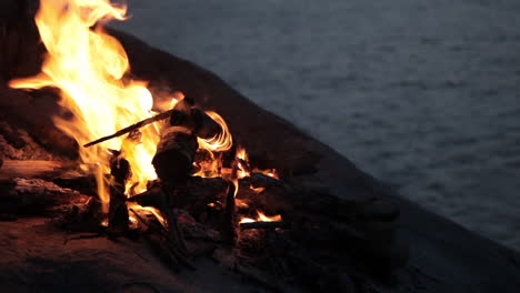 Camp-fire-on-a-hill-of-island-with-overview-of-sea-during-magic-hour