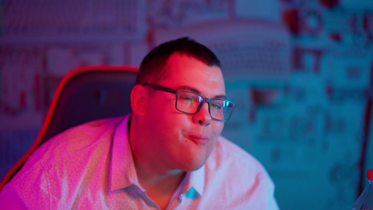 Young Man Happily Eating a Burger Under Neon Lights