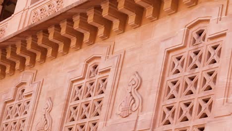 artistic-design-of-palace-wall-made-of-red-stone-at-day-from-flat-angle-video-is-taken-at-umaid-bhawan-palace-jodhpur-india