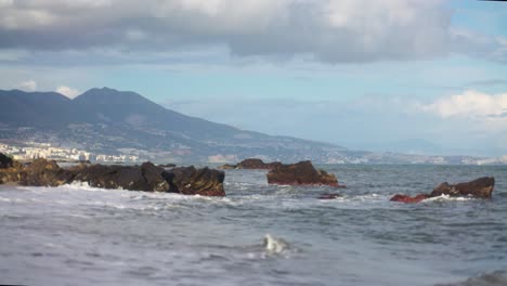 olas golpeando las rocas en la playa en cámara lenta