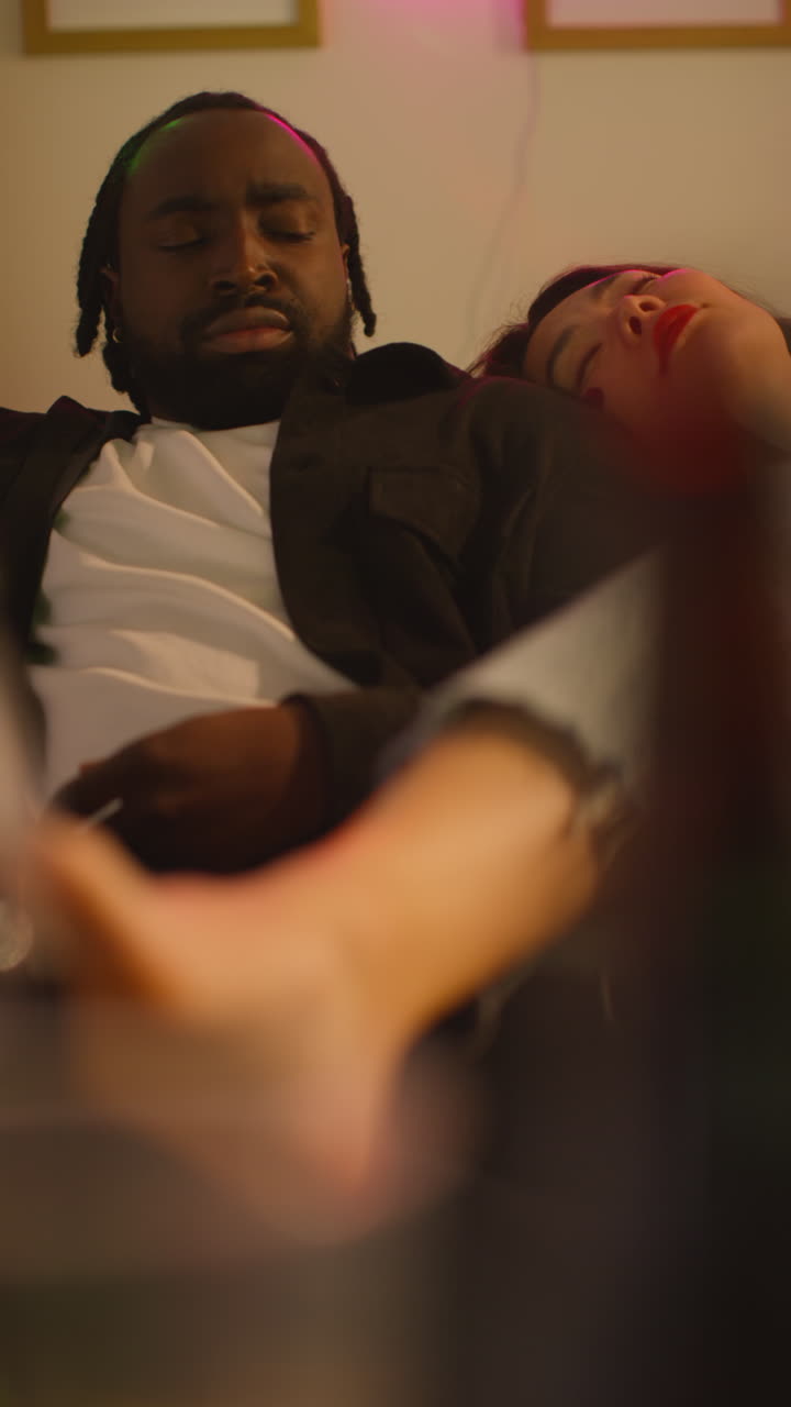 Vertical Video Of Couple Waking Up On Sofa After Drinking Alcohol At House Party Suffering With Hangover