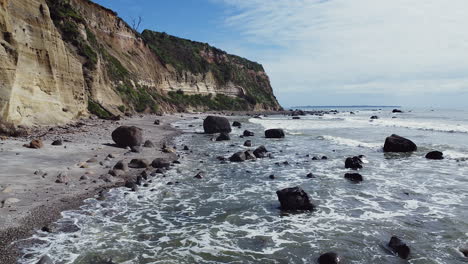 olas rompiendo en rocas en la orilla del mar en la playa de maketu, te-puke, bahía de la abundancia, isla del norte, nueva zelanda