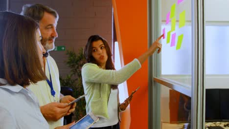 Business-colleagues-discussing-over-digital-tablet-and-sticky-notes-4k