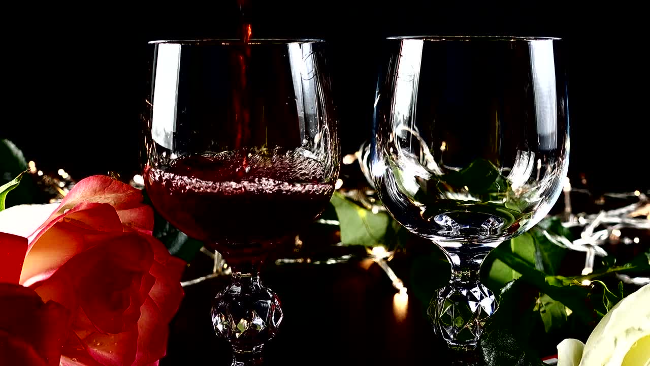 Weingläser und Rose vor dem Hintergrund heller Girlanden