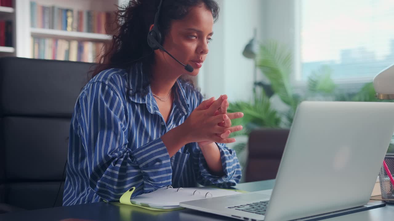 Operatrice con le cuffie che parla al telefono mentre è seduta alla sua postazione di lavoro.