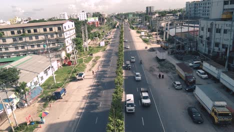 Aerial-shot-of-a-busy-road-where-vehicles-are-passing-in-Dhaka,-Bangladesh