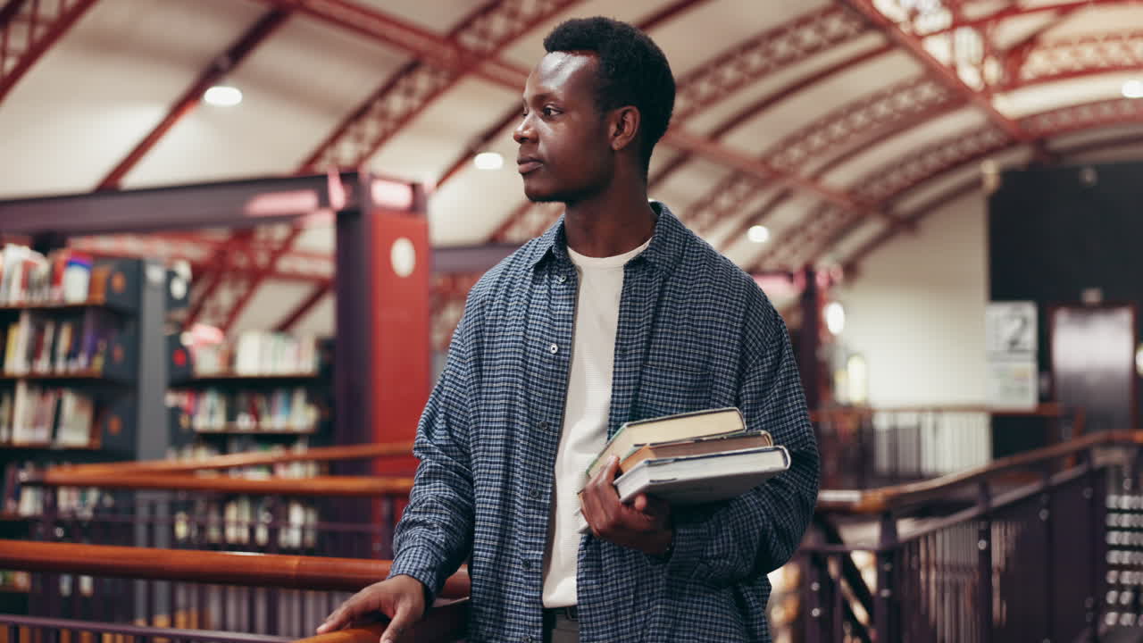 Man in a library holding books