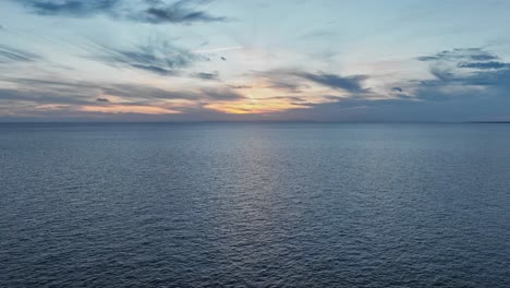 water passing by as the sun drops below the horizon to set