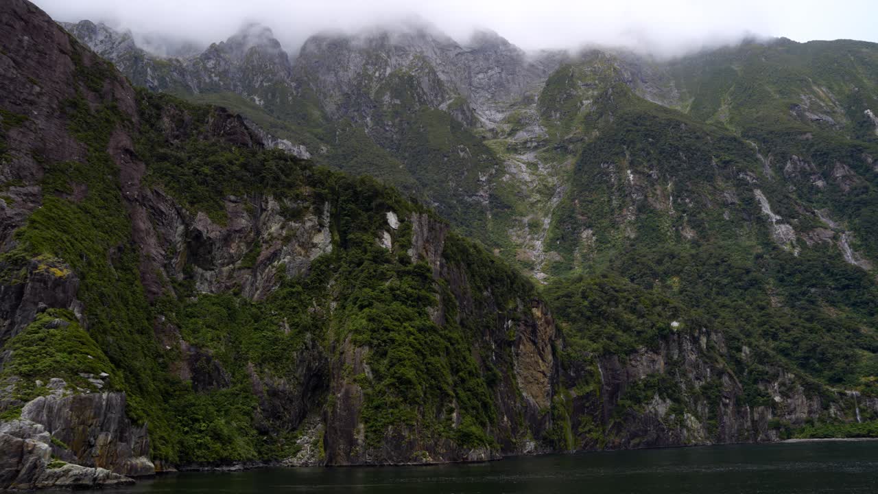 밀포드 사운드 (milford sound) 의 은 산맥과 구름 속에 숨겨진 봉우리.