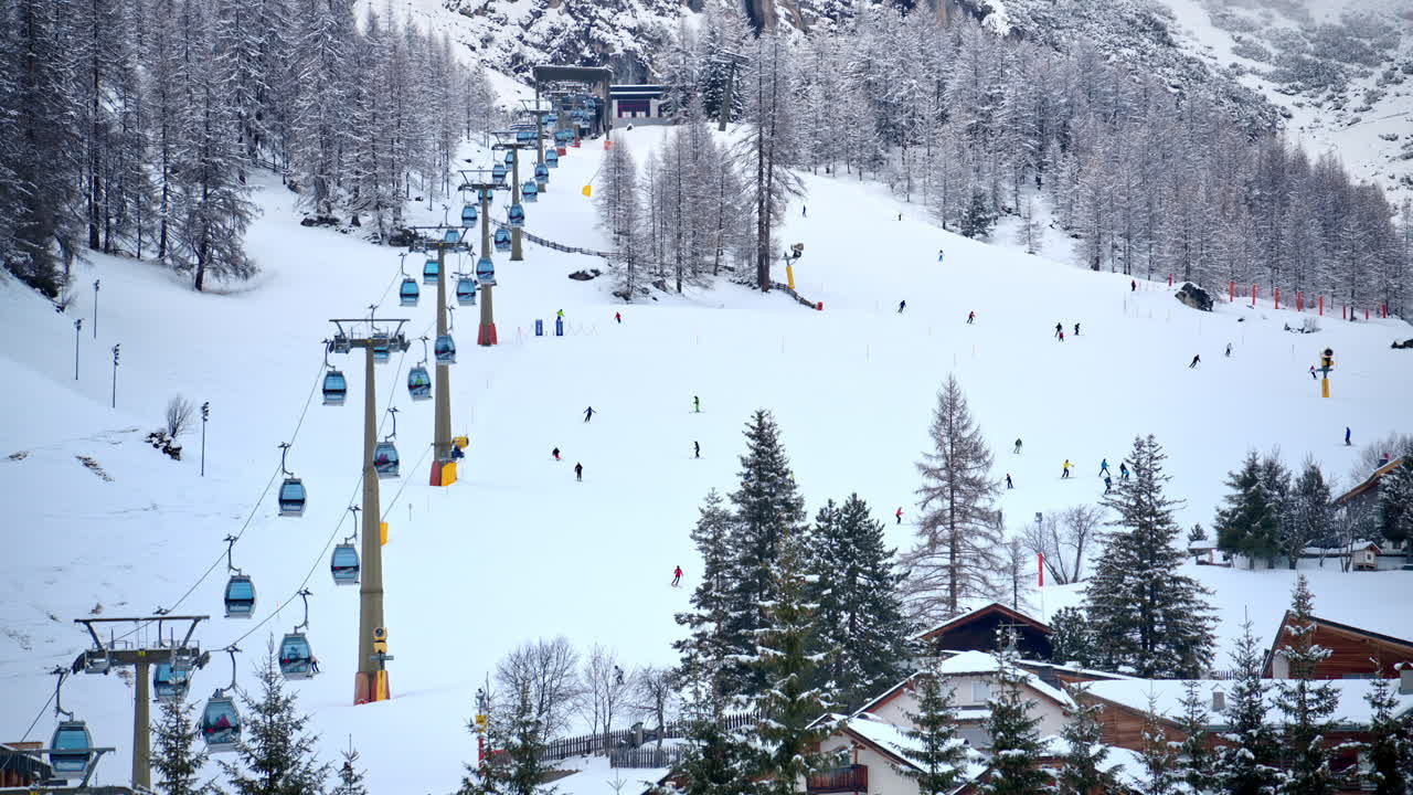 Distant view of people skiing at a ski resort near a ski lift in the Dolomites, Italy