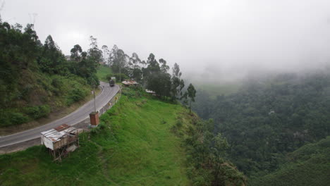 aerial shot in the jungle, following an abandoned mountain road in the valley landscape of south america, mystic high altitude, drone flies into a low foggy dense mist cloud