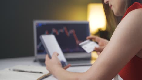 la mujer que monitorea el mercado de valores hace compras con una tarjeta de crédito.