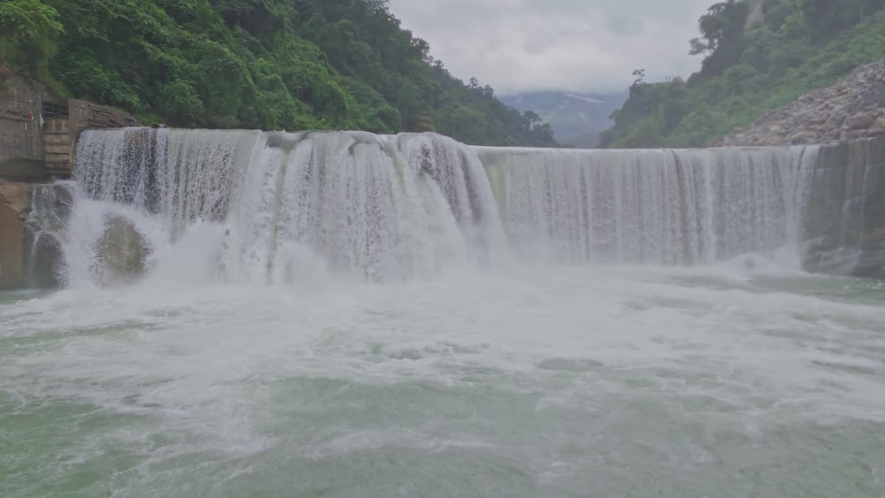 A breathtaking aerial view of a beautiful waterfall cascading through lush green mountains, showcasing the untouched beauty of nature, flowing water, and serene landscape scenery
