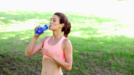 Fit-woman-stopping-to-take-a-drink-on-her-run