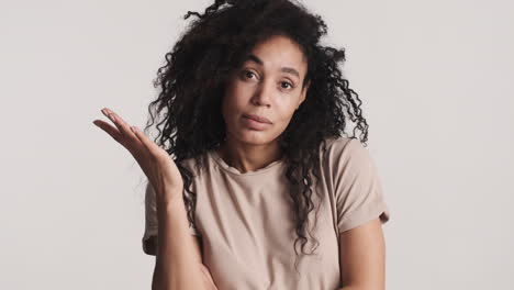 una mujer afroamericana pensativa sobre un fondo blanco.