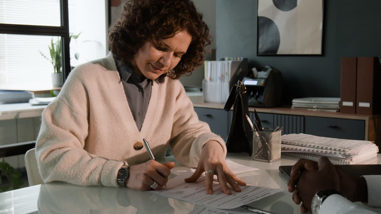Woman Signing Documents in an Office