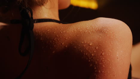 woman's wet shoulder in a sauna